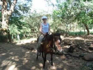 Touristin reitet auf einem Pferd durch den Dschungel von Nicaragua