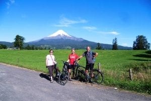Drei Touristen stehen mit dem E-Bike vor einem Vulkan in Chile